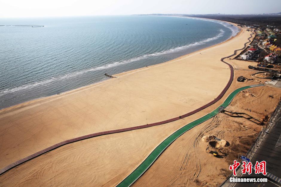 3月13日，秦皇島萬(wàn)米臨海沙灘木棧道。據(jù)了解，該木棧道全長(zhǎng)約4200米，與北戴河區(qū)原有的7500米木棧道對(duì)接后全線總長(zhǎng)度1.17萬(wàn)米，整個(gè)木棧道東起秦皇島體育基地游船碼頭，西至北戴河濕地公園，呈波浪形蜿蜒10.4公里海岸線。 中新社發(fā) 曹建雄 攝 CNSPHOTO