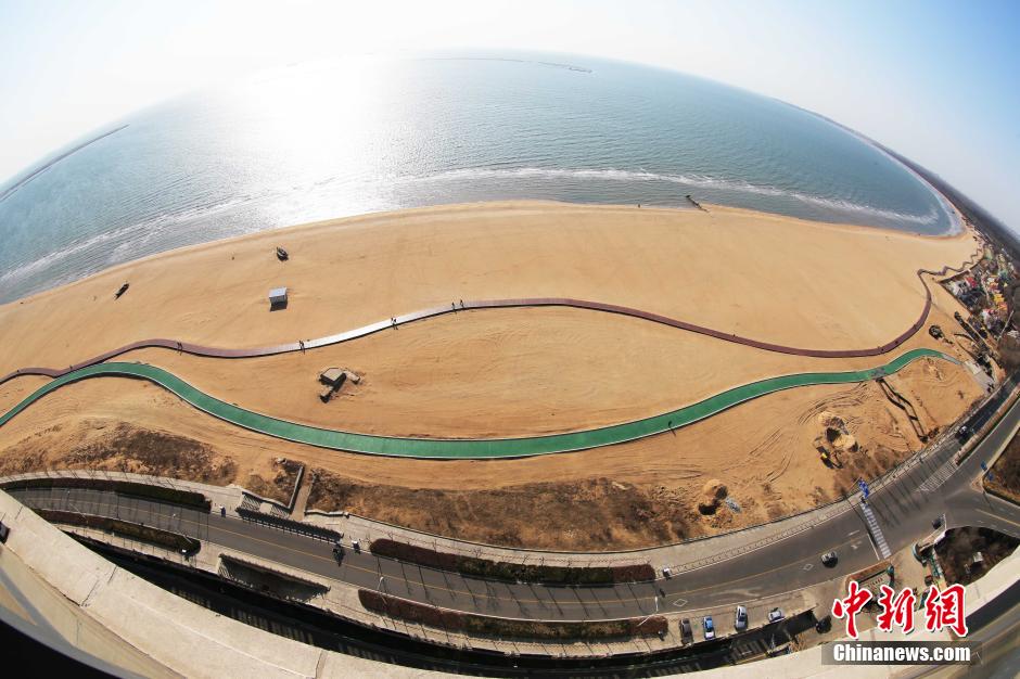 3月13日，秦皇島萬(wàn)米臨海沙灘木棧道。據(jù)了解，該木棧道全長(zhǎng)約4200米，與北戴河區(qū)原有的7500米木棧道對(duì)接后全線總長(zhǎng)度1.17萬(wàn)米，整個(gè)木棧道東起秦皇島體育基地游船碼頭，西至北戴河濕地公園，呈波浪形蜿蜒10.4公里海岸線。 中新社發(fā) 曹建雄 攝 CNSPHOTO